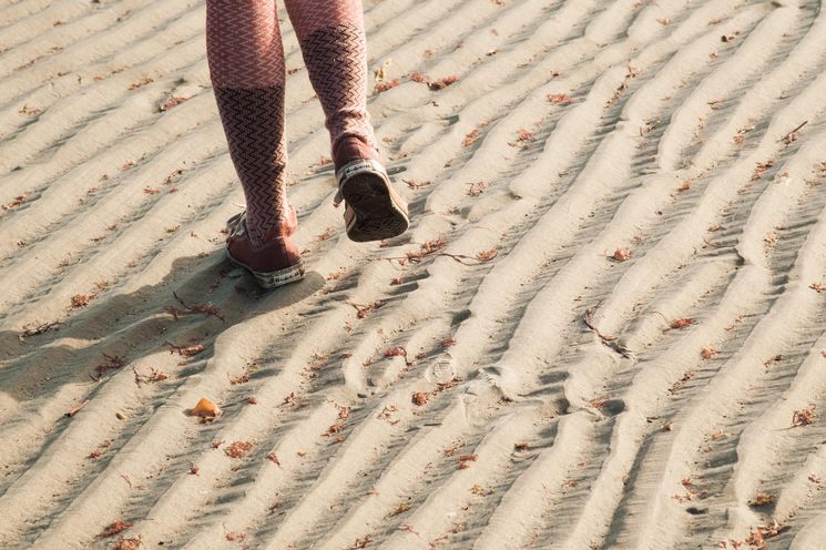 Feet walking on ridges of sand