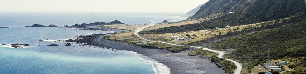Panoramic image of a dusty road winding across a coastline.